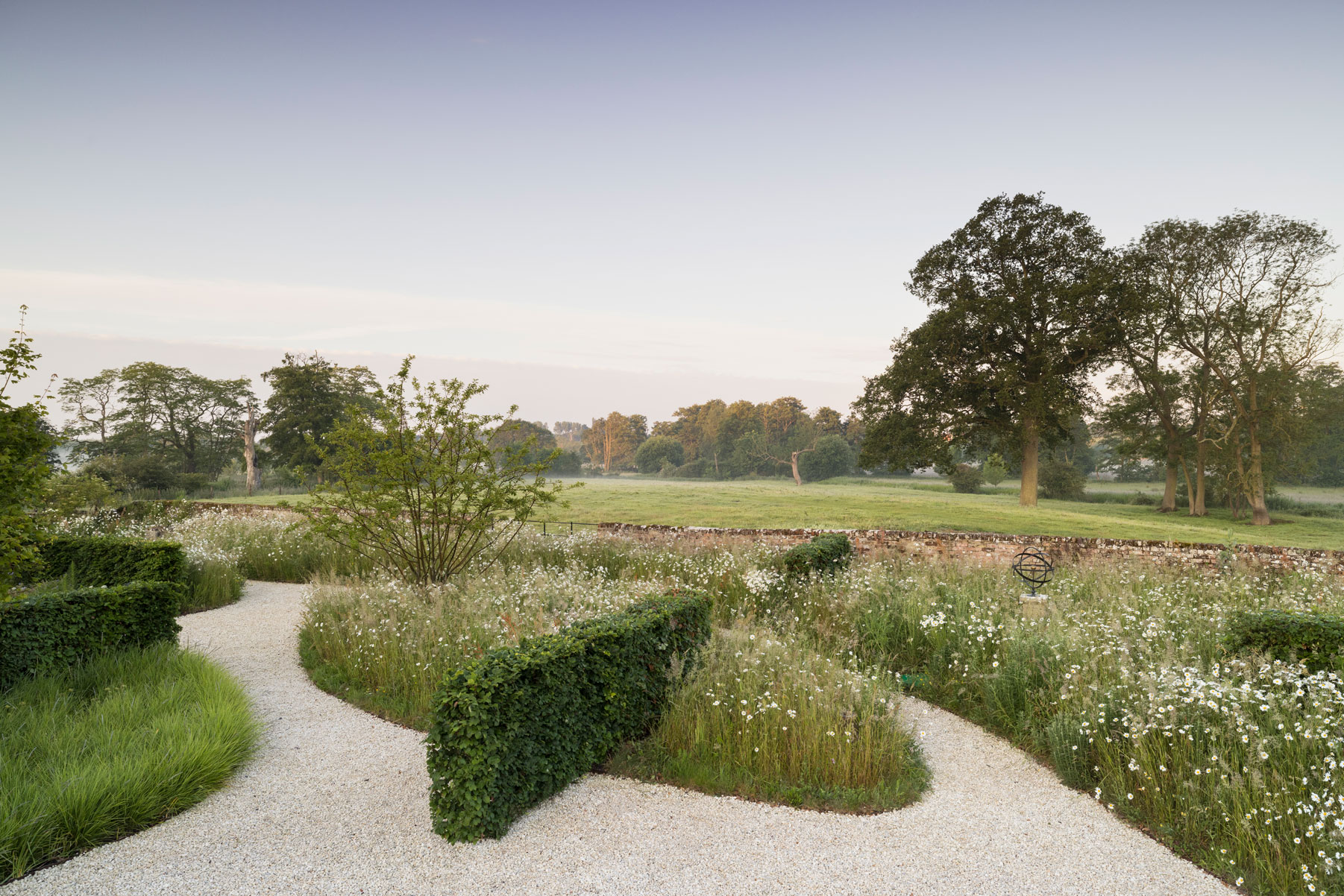 Colm Joseph suffolk garden design minimalist beech hedges ornamental grass planting sesleria wildflowers multi-stem crabapple trees old boundary wall landscape view