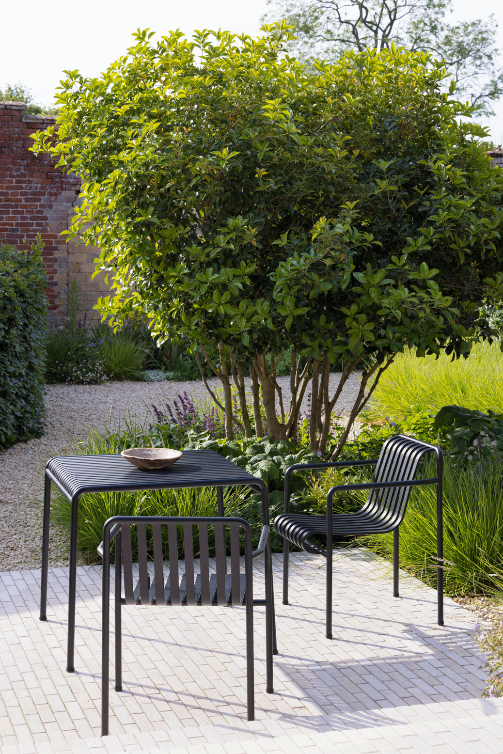 Colm Joseph suffolk garden naturalistic planting design limestone pavers furniture osmanthus multi-stem tree old wall