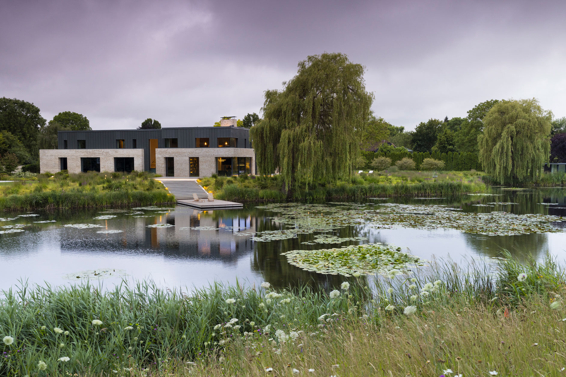 Colm Joseph modern country garden cambridgeshire lake view contemporary home floating seating deck concrete steps natural planting